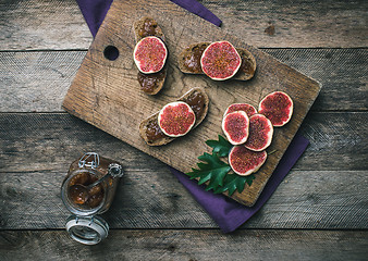 Image showing figs, nuts and bread with jam on wooden choppingboard