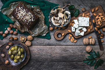 Image showing Rustic style olives, nuts mushrooms  and bread  with seeds