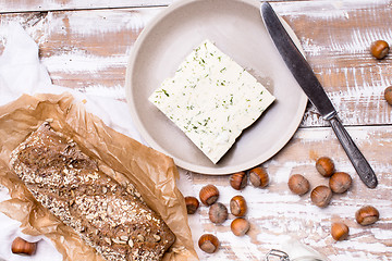 Image showing cheese with dill and bread huzelnuts on wooden board