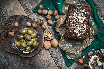 Image showing Green olives, nuts mushrooms  and bread with seeds