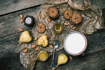 Image showing Tasty Pears almonds Cookies and milk on rustic wood