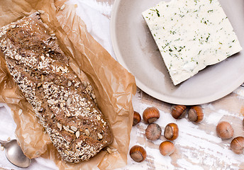 Image showing Bread with cheese and huzelnuts for breakfast on board