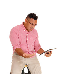 Image showing Man angry at his tablet computer.