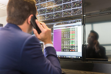 Image showing Stock trader looking at computer screens.