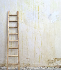 Image showing weathered stucco wall with wooden ladder