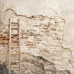 Image showing weathered stucco wall with wooden ladder