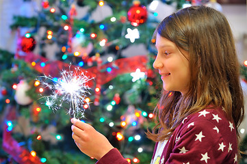 Image showing Portrait of cute girl looking at fire sparks.