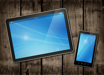 Image showing Smartphone and digital tablet PC on a dark wood table