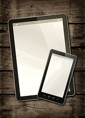 Image showing Smartphone and digital tablet PC on a dark wood table
