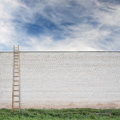 Image showing Blue sky behind the huge wall with a wooden ladder