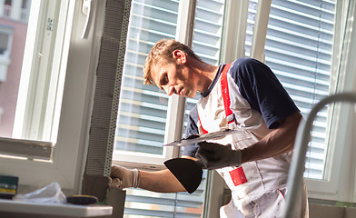 Image showing Plasterer renovating indoor walls and ceilings.