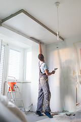 Image showing Plasterer renovating indoor walls and ceilings.