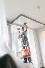 Image showing Plasterer renovating indoor walls and ceilings.