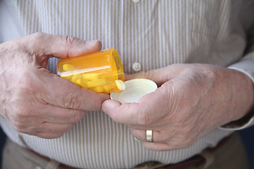 Image showing senior man taking prescription pills