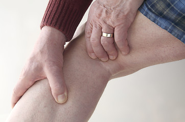 Image showing Man checks pain in his leg