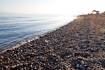 Image showing stone in the coastline sunrise and parasol