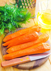 Image showing raw carrots and knife on the wooden board