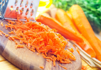 Image showing raw carrots and knife on the wooden board