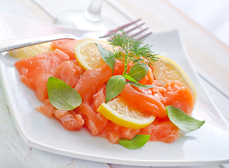 Image showing fresh salmon with lemon on the white plate