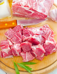 Image showing raw meat and knife on the wooden board