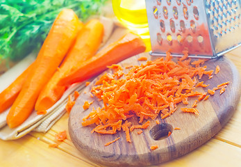 Image showing raw carrots and knife on the wooden board