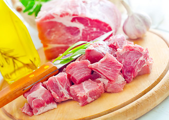 Image showing raw meat and knife on the wooden board