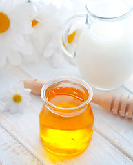 Image showing fresh honey in the glass bank and milk in jug