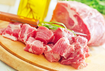 Image showing raw meat and knife on the wooden board