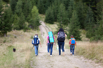 Image showing Family walk with backpacks from back