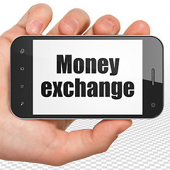 Image showing Banking concept: Hand Holding Smartphone with Money Exchange on display