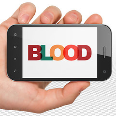 Image showing Health concept: Hand Holding Smartphone with Blood on  display