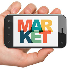 Image showing Marketing concept: Hand Holding Smartphone with Market on  display