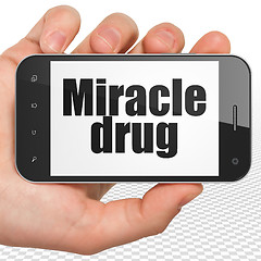 Image showing Medicine concept: Hand Holding Smartphone with Miracle Drug on display