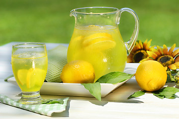 Image showing Pitcher of cool lemonade with glass on table