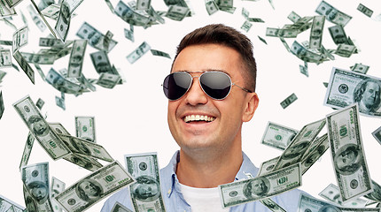 Image showing happy man in sunglasses with falling dollar money