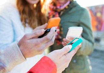 Image showing close up of friends with smartphones outdoors