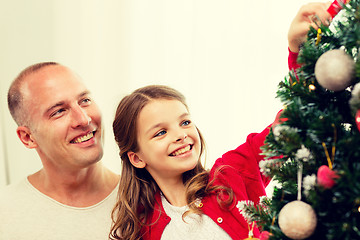 Image showing smiling family decorating christmas tree at home