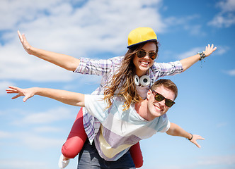 Image showing smiling teenagers in sunglasses having fun outside