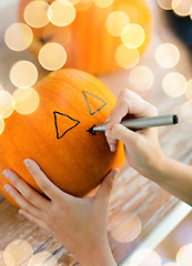 Image showing close up of woman with pumpkins at home