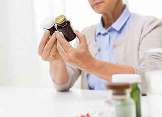 Image showing close up of senior woman with medicine jars