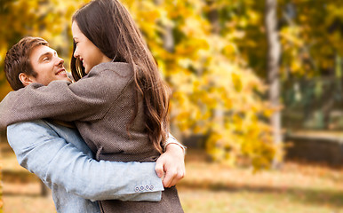 Image showing smiling couple hugging over autumn background