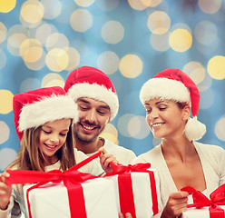 Image showing happy family in santa helper hats with gift boxes