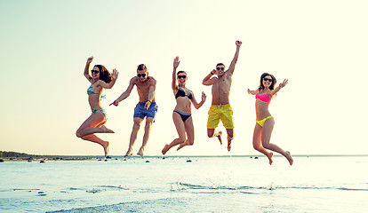 Image showing smiling friends in sunglasses on summer beach