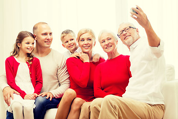 Image showing smiling family with camera at home