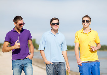 Image showing happy friends drinking beer and walking on beach