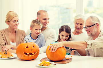 Image showing happy family sitting with pumpkins at home