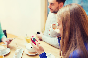 Image showing couple with smartphones drinking tea