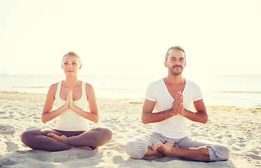 Image showing smiling couple making yoga exercises outdoors