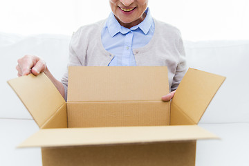 Image showing close up of senior woman with parcel box at home