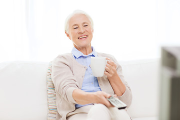 Image showing senior woman watching tv and drinking tea at home